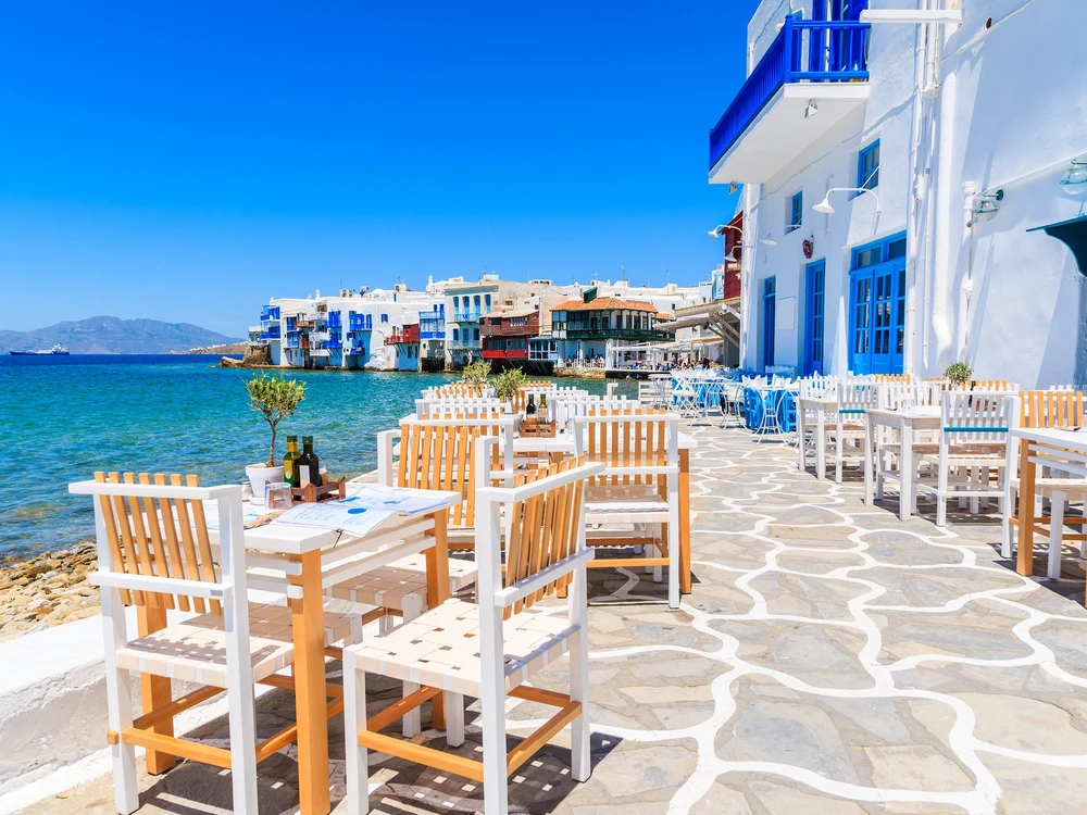Chairs with tables in typical Greek tavern in Little Venice part of Mykonos town, Mykonos island, Greece