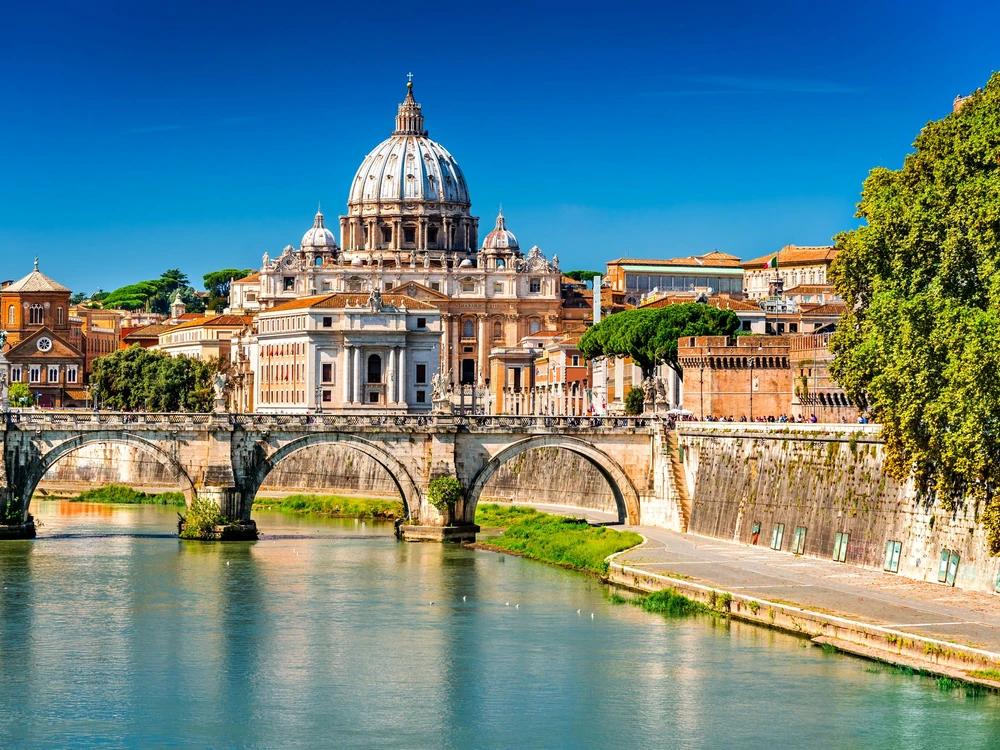 Rome, Italy. Vatican dome of Saint Peter Basilica (Italian: San Pietro) and Sant Angelo Bridge, over Tiber river.