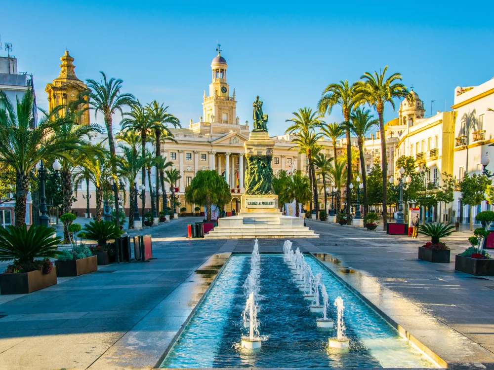 View of a fountain situated on the square of saint john of god in cadiz with town hall on background