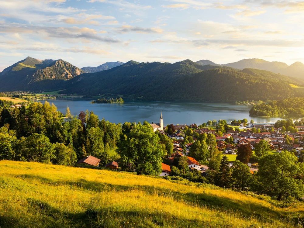 View of mountains and mountain lake during sunset in summer. Beautiful town of Schliersee in Bavaria, Germany, Europe.