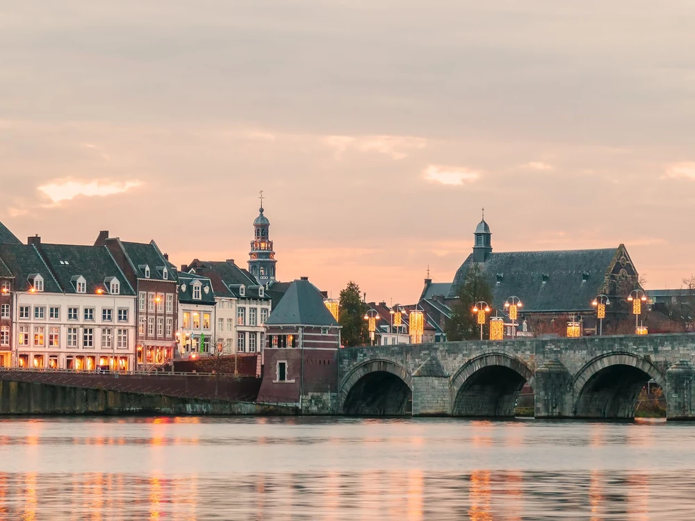 Panoramic view at the famous Dutch Sint Servaas bridge with lights in the city center of Maastricht