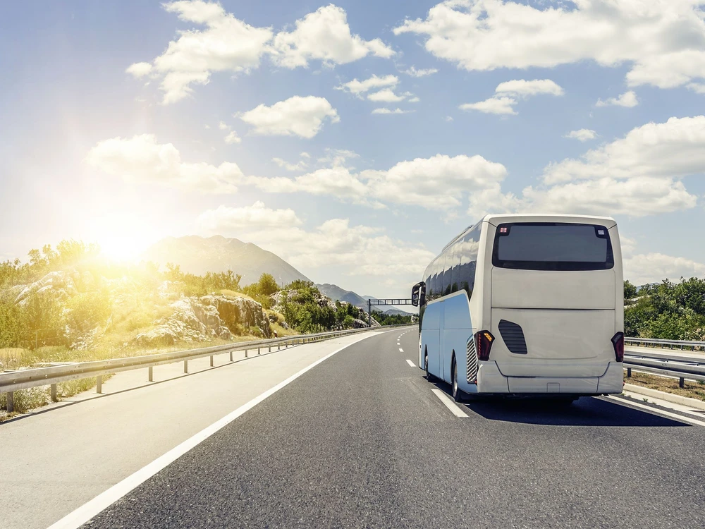 Tourist bus rushes along the asphalt high-speed highway.