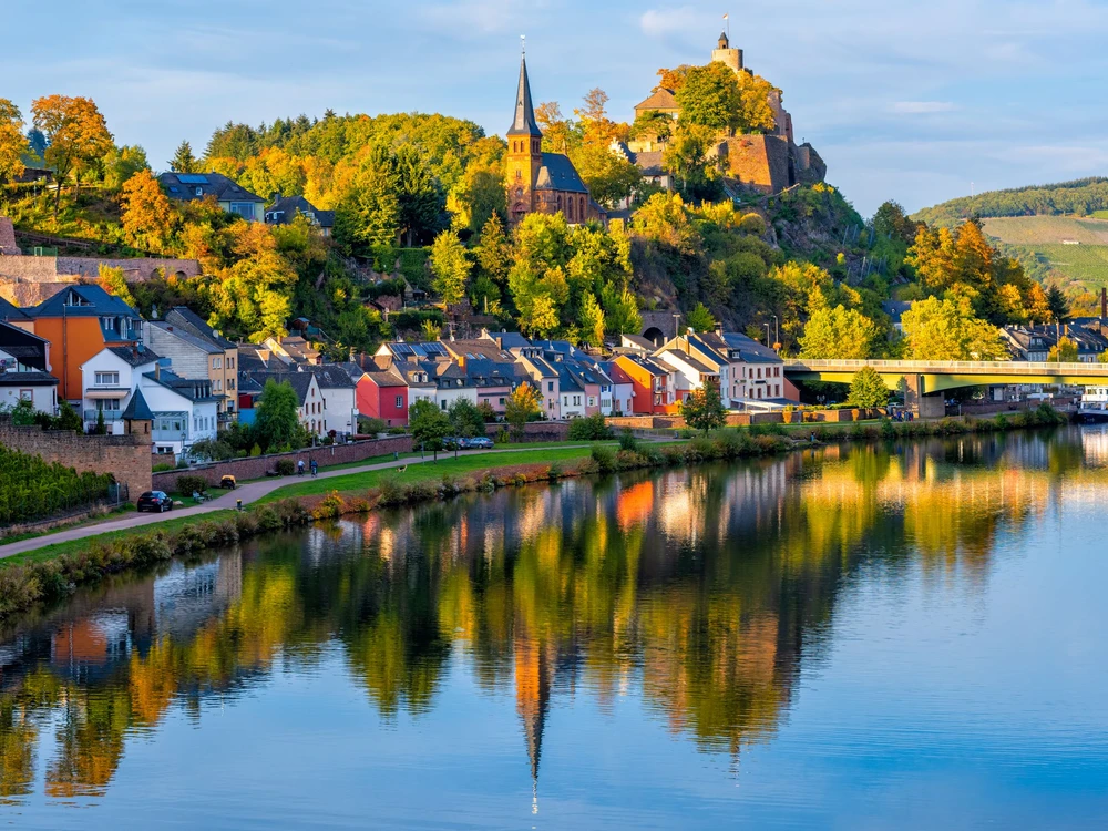 Medieval Saarburg town reflecting in Saar river on a sunny autumn day, Saarland, Germany