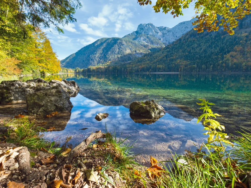 Sunny idyllic colorful autumn alpine view. Peaceful mountain lake with clear transparent water and reflections. Langbathseen lake, Upper Austria.