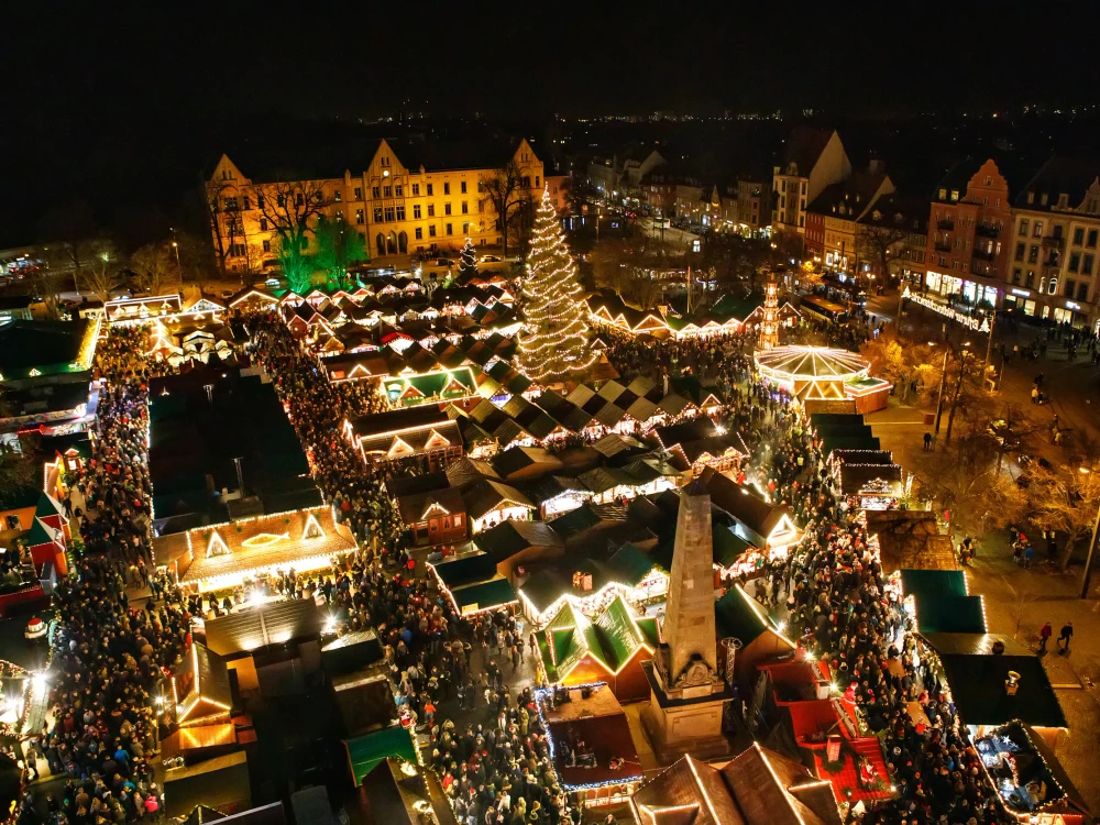 Traditional Christmas market in Erfurt, Thuringia in Germany. With xmas tree, pyramide and sales and food stands on late evening or night