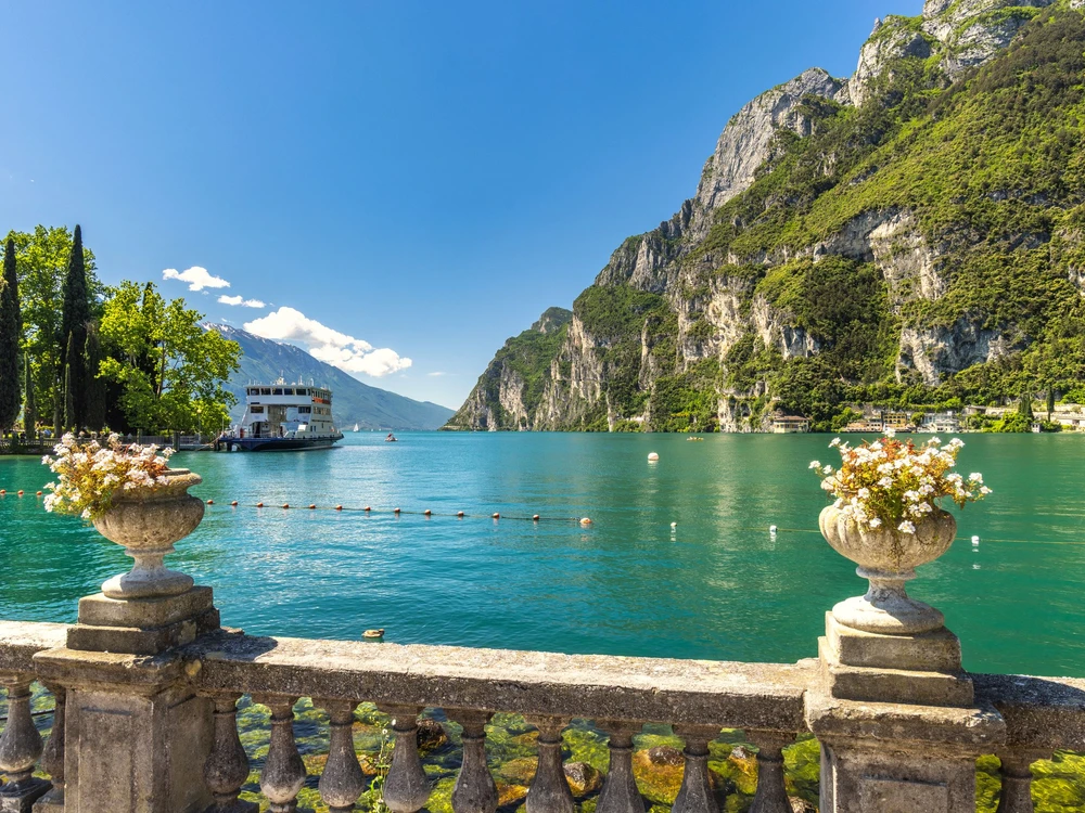 Lake Garda with mountains in background, view from Riva del Garda town shore, Italy, Europe.
