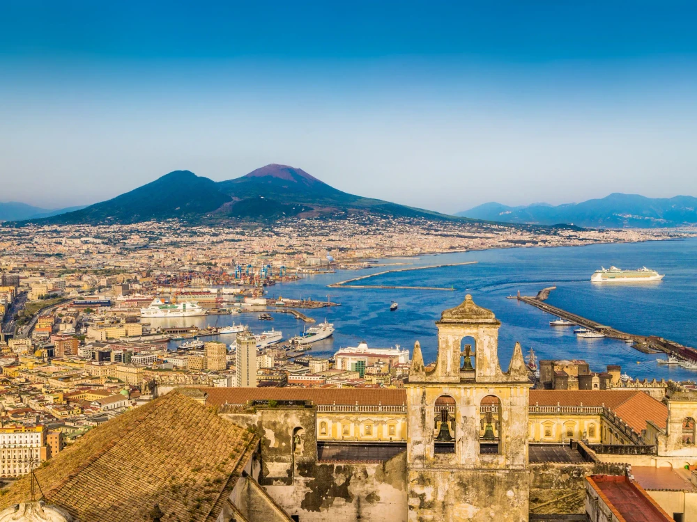 Scenic picture-postcard view of the city of Napoli (Naples) with famous Mount Vesuvius in the background in golden evening light at sunset, Campania, Italy