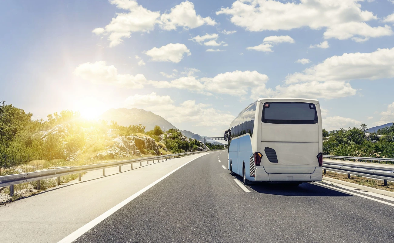 Tourist bus rushes along the asphalt high-speed highway.