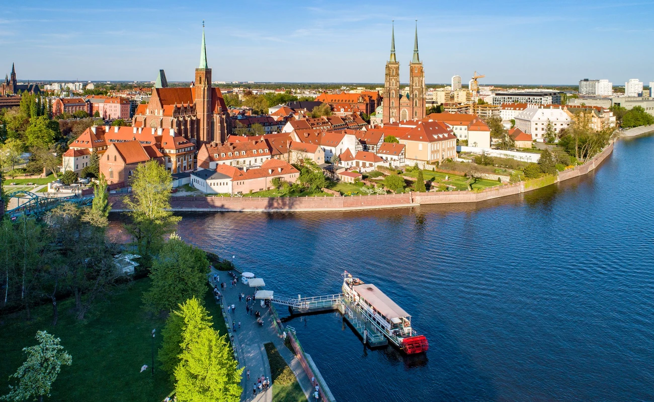 Poland. Wroclaw. Ostrow Tumski, Gothic cathedral of St. John the Baptist,  Collegiate Church of the Holy Cross, Archbishop's palace, tourist harbor, ship and Odra (Oder) River. Aerial view at sunset