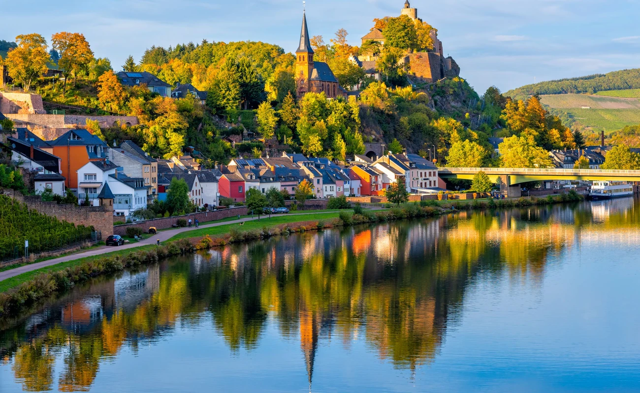Medieval Saarburg town reflecting in Saar river on a sunny autumn day, Saarland, Germany