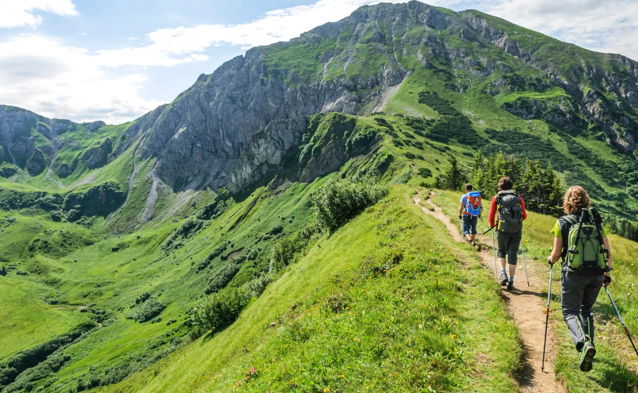 Wanderer sind im Bereich sind rund um die Erlebnisberge Kanzelwand und Fellhorn in der Grenzregion Oberallgäu/Kleinwalsertal unterwegs und genießen die herrliche Natur an einem Sommermorgen.