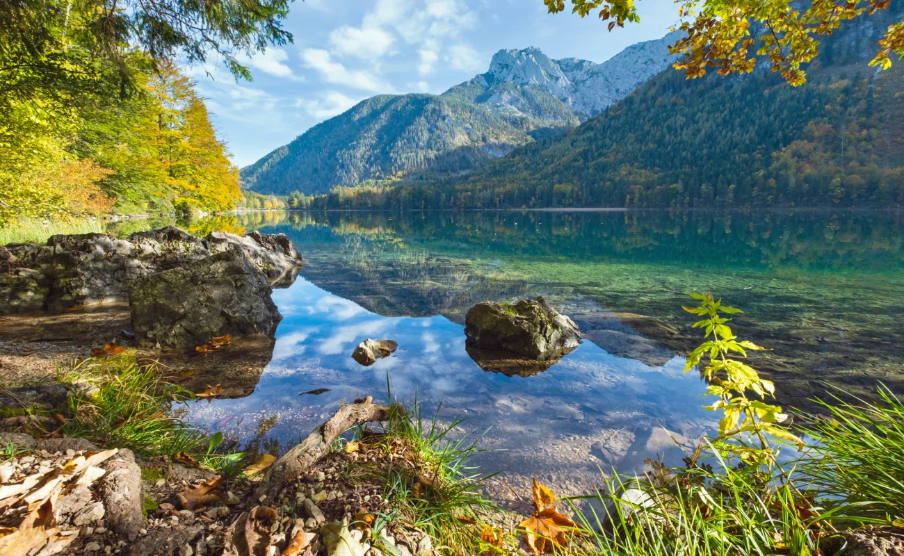 Sunny idyllic colorful autumn alpine view. Peaceful mountain lake with clear transparent water and reflections. Langbathseen lake, Upper Austria.