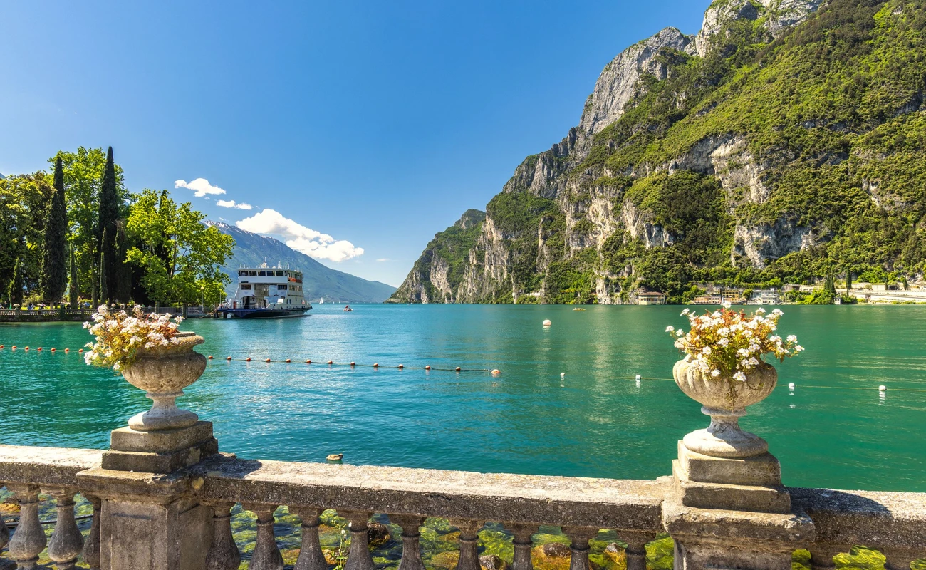Lake Garda with mountains in background, view from Riva del Garda town shore, Italy, Europe.